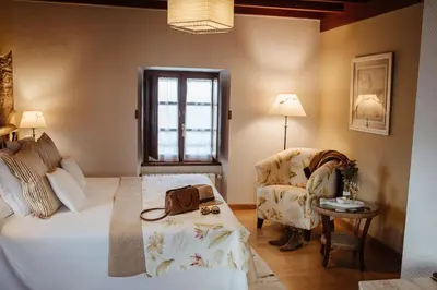 a hotel room with a bed and a chair at Hotel Pleamar in Puerto de Vega