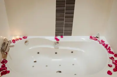 a white bath tub with pink flowers around it at Hotel Pleamar in Puerto de Vega