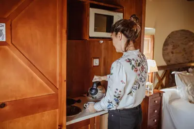 a woman standing in a kitchen in a train at Hotel Pleamar in Puerto de Vega