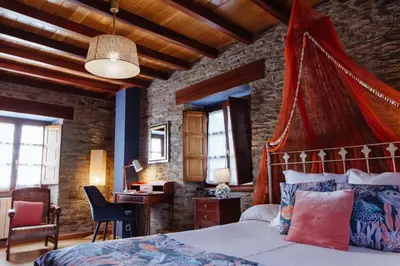 a bedroom with a bed with a red canopy at Hotel Pleamar in Puerto de Vega