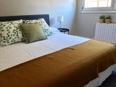 a bedroom with a bed with a yellow blanket and pillows at ***NUEVO Piso en Ourense WIFI Parking*** in Ourense