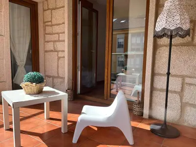 a table and a white chair and a lamp at Casa JyM Fontela 24 in O Pedrouzo