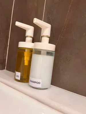 two bottles of honey on a shelf in a bathroom at Casa JyM Fontela 24 in O Pedrouzo