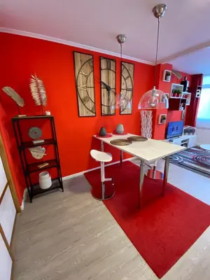 a living room with a table and a red wall at Apartamento Centro Frente Muralla 2 in Lugo