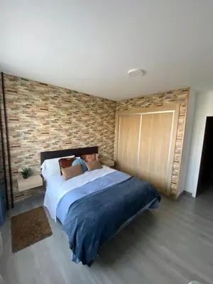 a bedroom with a large bed with a brick wall at Precioso piso en el centro de Galicia. in Silleda