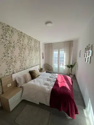 a bedroom with a large bed with a red blanket at Precioso piso en el centro de Galicia. in Silleda