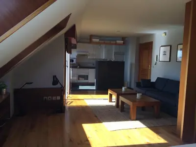 a living room with a blue couch and a table at Attic loft to wake up by the sea. in Sada