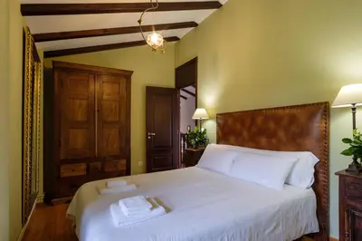 a bedroom with a white bed with two towels on it at Aldea A Paínza in Arzúa