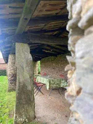 a table and chairs sitting under a bridge at Aldea A Paínza in Arzúa