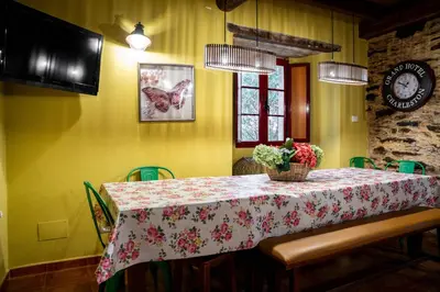 a dining room with a table with a floral table cloth at Aldea A Paínza in Arzúa