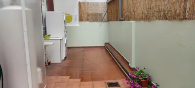 a hallway of a kitchen with a sink and a refrigerator at Albergue Santos in Santiago de Compostela