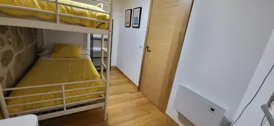 a bedroom with a large bed and a wooden floor at Casa Cerralleiro. Casa vacacional en Parada de Sil. Ribeira Sacra. in Parada del Sil