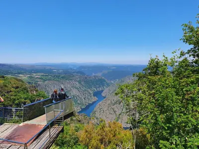 two people standing on a viewing platform overlooking a river at Casa Cerralleiro. Casa vacacional en Parada de Sil. Ribeira Sacra. in Parada del Sil