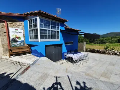 a blue house with a table in front of it at Casa Cerralleiro. Casa vacacional en Parada de Sil. Ribeira Sacra. in Parada del Sil
