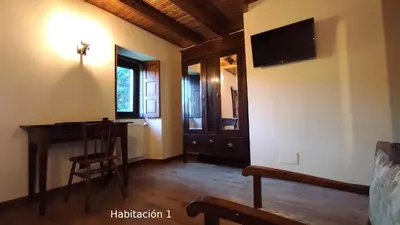 a room with a desk and a television on the wall at Casa do Médico in Presqueira