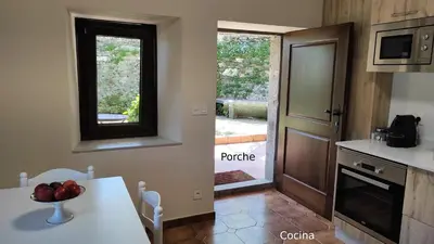 a kitchen with a table with a bowl of fruit on it at Casa do Médico in Presqueira