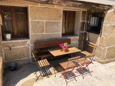 a wooden table and chairs with flowers on a patio at Ribeira Sacra II - Ourense in Nogueira de Ramuin