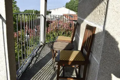 a balcony with two chairs and a table and a fence at Ribeira Sacra II - Ourense in Nogueira de Ramuin