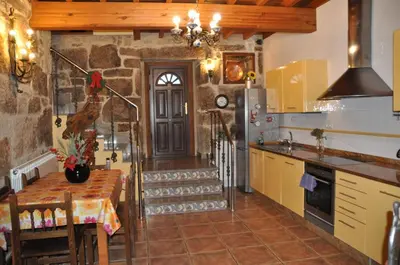 a kitchen with a table and a refrigerator and a door at CASA BOREAL in Ourense