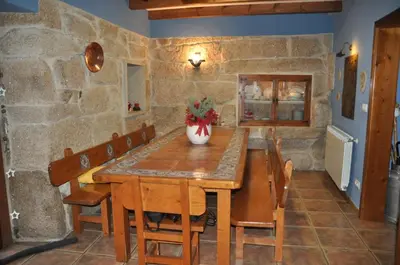 a dining room with a wooden table and chairs at CASA BOREAL in Ourense