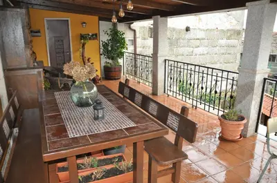 a wooden table and benches on a balcony with flowers at CASA BOREAL in Ourense