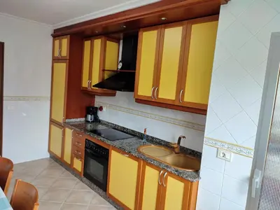 a kitchen with yellow cabinets and a sink at ACT RIOCOBO in Cervo
