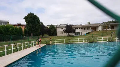 a group of people standing around a swimming pool at ACT RIOCOBO in Cervo