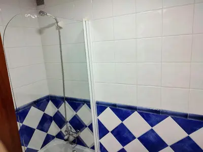 a bathroom with a shower with blue and white tiles at ACT RIOCOBO in Cervo