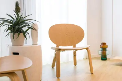 a wooden chair in a room with a plant at SEIS ALDABAS Apartamentos in Santiago de Compostela