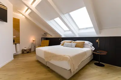 a bedroom with a large bed and a skylight at SEIS ALDABAS Apartamentos in Santiago de Compostela
