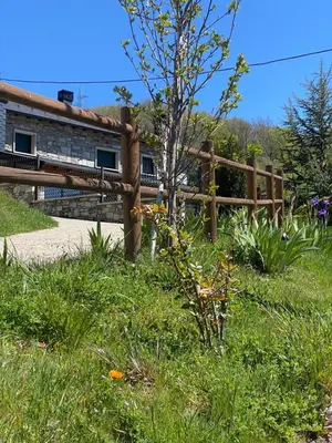 a wooden fence in the grass near a building at Villa Adilia in Padornelo