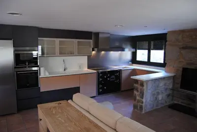 a living room with a couch and a kitchen at Villa Adilia in Padornelo