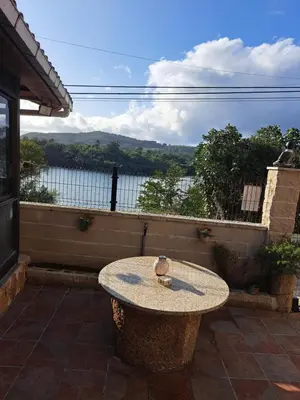 a table on a patio with a view of the water at Casa Justa in Castrelo de Miño