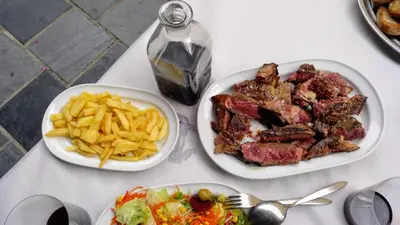 a table with two plates of food and french fries at Casa Gayón in Pola de Allande