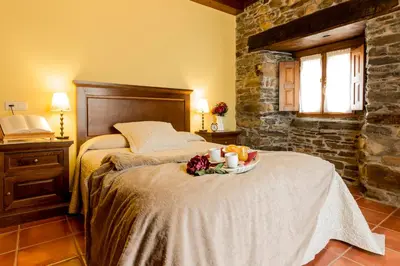 a bedroom with a bed with a tray of fruit and candles at Casa Gayón in Pola de Allande