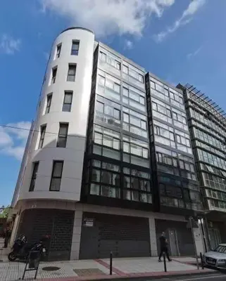 a tall building with a person walking in front of it at Apartamento Carreira Sada in Sada