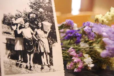 an old photo of three women standing next to flowers at Casa Rural La Torre De Babel in Molinaseca