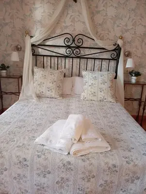 a bed with a white comforter and pillows at Casa Rural La Torre De Babel in Molinaseca