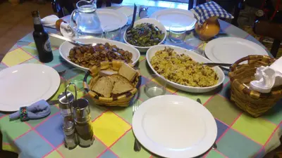 a table with plates and bowls of food on it at Reitoral de Chandrexa in Parada del Sil
