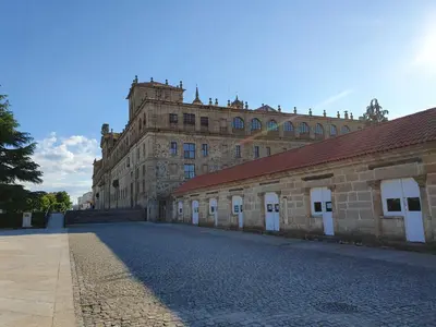 a large brick building with white doors on a street at Acogedor apartamento en el centro de Monforte in Monforte de Lemos