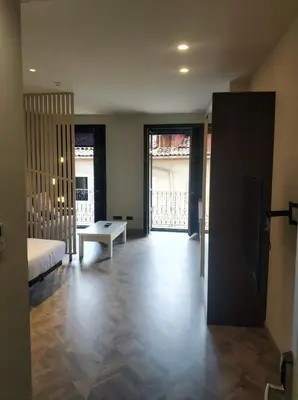 a room with a bed and a tv and a table at Apartamentos Turísticos y Habitaciones Cidade Vella by Bossh! Hotels in Ourense