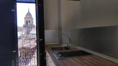 a kitchen with a sink and a window with a tower at Apartamentos Turísticos y Habitaciones Cidade Vella by Bossh! Hotels in Ourense