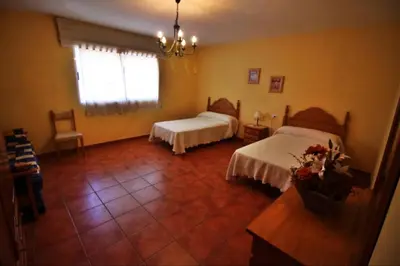 a bedroom with two beds and a table and a window at Casa de Padrón in Padrón