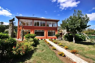 a large orange house with a garden at Casa de Padrón in Padrón