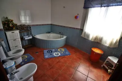 a bathroom with a tub and a toilet and a sink at Casa de Padrón in Padrón