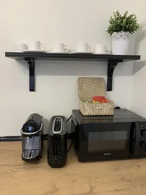 a shelf on a wall above a microwave and a chair at Apartamentos San Lazaro in Santiago de Compostela