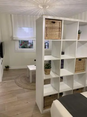 a bedroom with a white book shelf next to a bed at Apartamentos San Lazaro in Santiago de Compostela