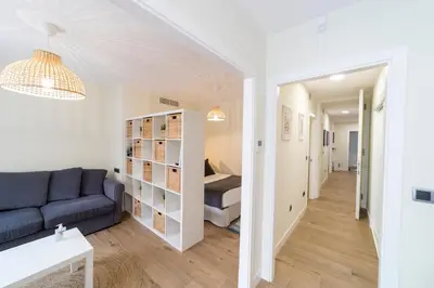 a living room with a blue couch and a hallway at Apartamentos San Lazaro in Santiago de Compostela
