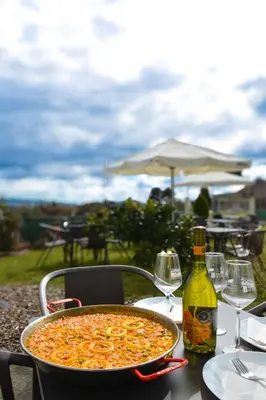 a pizza sitting on a table with a bottle of wine at Albergue Melide in Melide