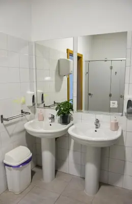 a bathroom with two sinks and a mirror at Albergue Melide in Melide